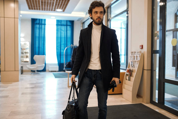 good looking confident man in fashion casual clothes advertising bag - Fotó, kép