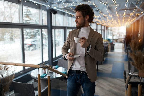 attractive guy enjoying hot coffee at the cafe - Фото, зображення