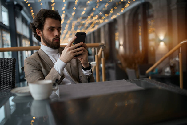 serious elegant guy using his smart phone - Фото, изображение