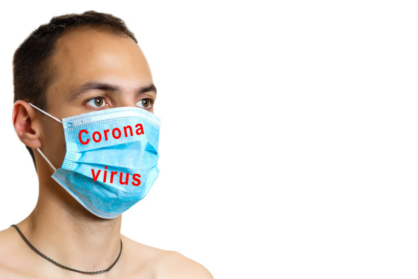 Portrait of a sick man wearing medical mask with coronavirus text at white background. Coronavirus concept. Protect your health. - Fotoğraf, Görsel