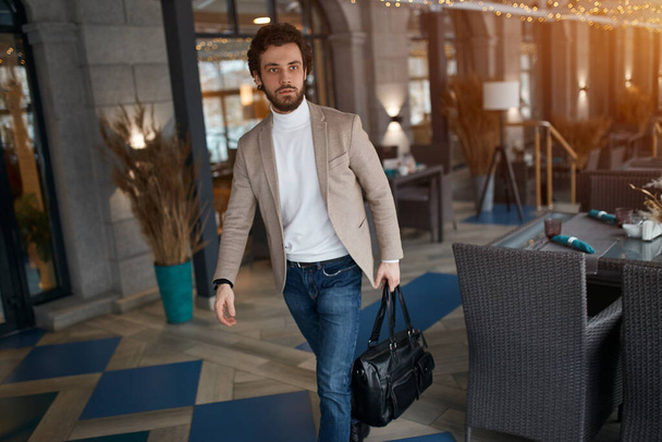 young pleasant brunette guy holding a bag, selling goods - Fotografie, Obrázek