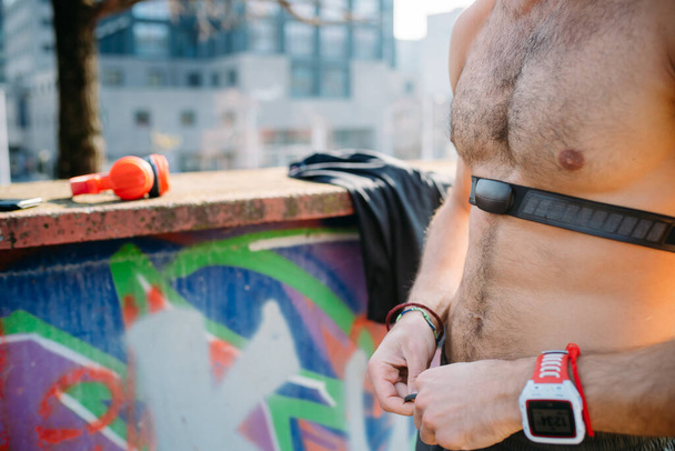 Middle section young man using sport gadget and fit smartwatch - σπορ, αξεσουάρ, υγιή έννοια - Φωτογραφία, εικόνα