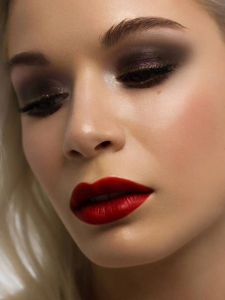 Close-up portrait of beautiful woman's purity face with dark burgundy smoky-eyes make-up, red full lips. Sexy model with clean shiny skin, purity complexion - Foto, Imagem
