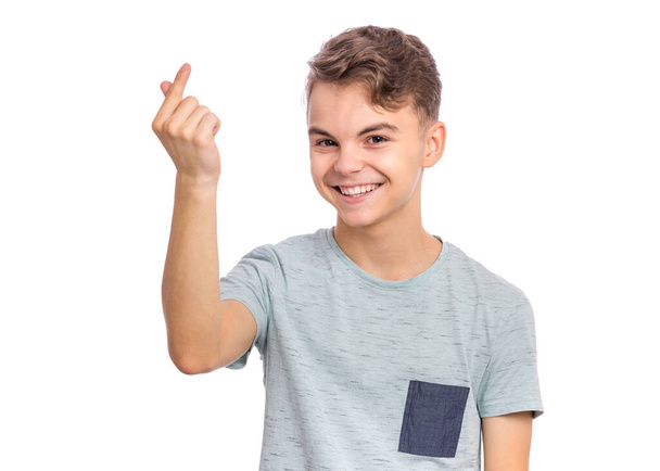 Portrait of handsome young teen boy showing sign symbol of money by fingers, isolated on white background. Smiling child doing rich gesture. Teenager making cash sign gesture rubbing fingers together. - 写真・画像