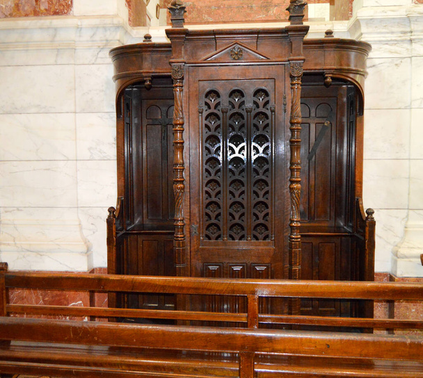 Holzgeschnitzte Fenster des Beichtstuhls in der Kirche. - Foto, Bild