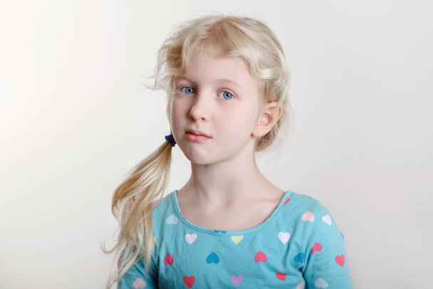 Portrait of beautiful pensive arrogant Caucasian girl with messy blonde hair looking in camera. Moody grumpy preschool child kid with attitude. Negative emotion face expression.  - Foto, afbeelding