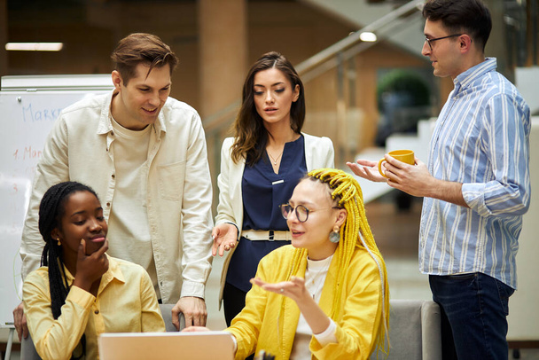 beautiful girl with yellow dread explaining something to her colleagues - Foto, Imagem