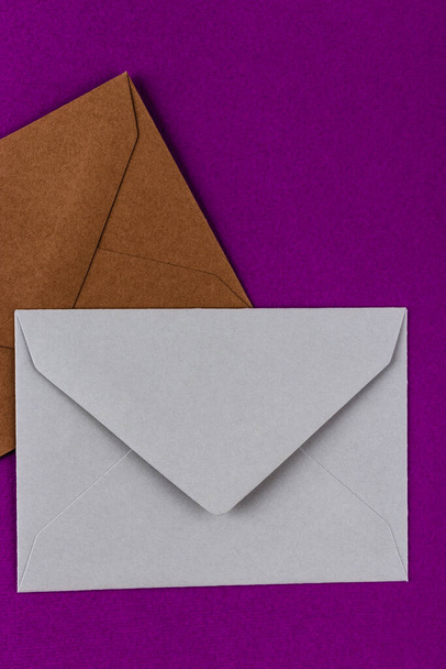 Красочные конверты на фиолетовом фоне. Почтовые конверты на столе
. - Фото, изображение