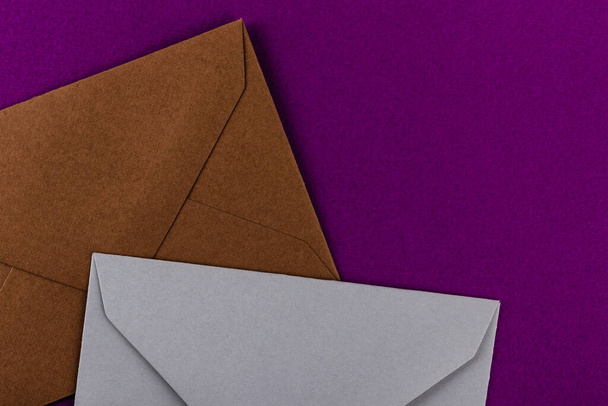 Colorful envelopes on a purple background. Mail envelopes on the table. - Фото, изображение