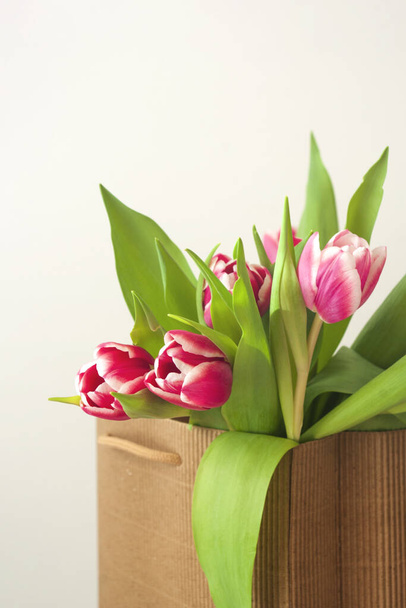rózsaszín tulipán csokor, anyák napja, Valentin nap, tavasz, papír zacskó. Romantikus háttér virágokkal. - Fotó, kép