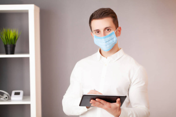 Homme travaillant dans le bureau portant un masque de protection contre le coronavirus
 - Photo, image