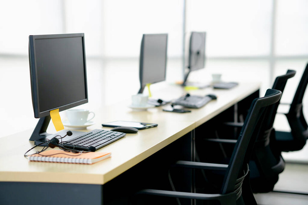 Seitenansicht der Stühle Computer und Headset in einem modernen Büro oder Schulungszentrum - Foto, Bild