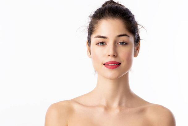 Close-up portrait of beautiful woman with flawless skin wearing red lipstick while standing at isolated white background.  - Φωτογραφία, εικόνα