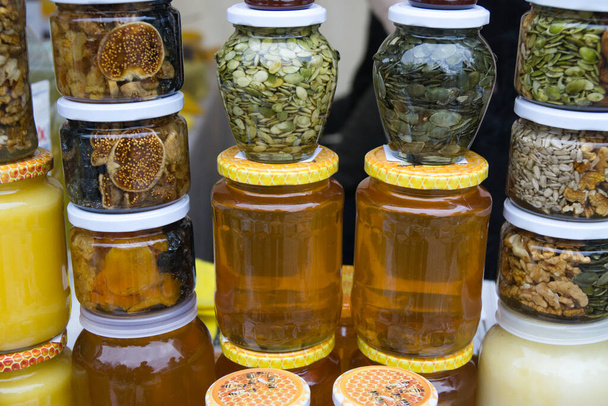 Montón de tarros de miel de vidrio en el mercado de los agricultores. Miel casera
. - Foto, imagen
