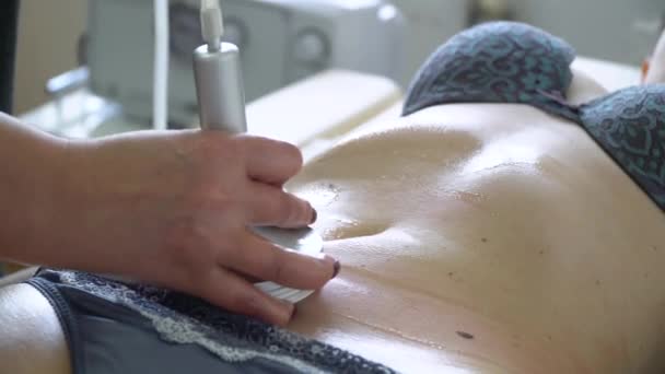 Vacuum massage of the abdomen. Young woman getting anti-cellulite and anti-fat therapy in beauty salon. Body care. Loss weight equipment - Materiał filmowy, wideo