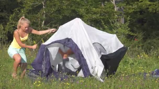 Timelapse: Férfi és nő vitatkoznak a kemping előkészítése és a sátor felállítása közben. - Felvétel, videó