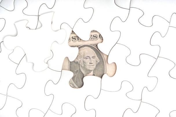US-Dollar-Banknoten auf weißem Puzzle. Geschäfts- und Kopierraumkonzept - Foto, Bild