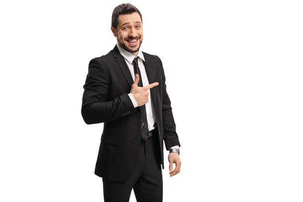 Confident businessman in a suit laughing and pointing isolated on white background - Фото, изображение
