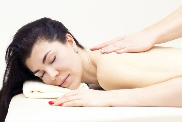 massage in a spa salon for a girl. Wellness massage concept. light background - Foto, afbeelding