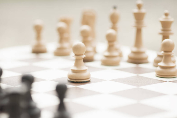 Το λευκό πιόνι σκάκι αρχίζει το παιχνίδι στη σκακιέρα.. - Φωτογραφία, εικόνα