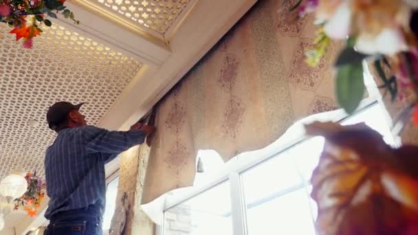 hombre de servicio se quita rápidamente las cortinas con cierre de velcro para persianas romanas
 - Metraje, vídeo