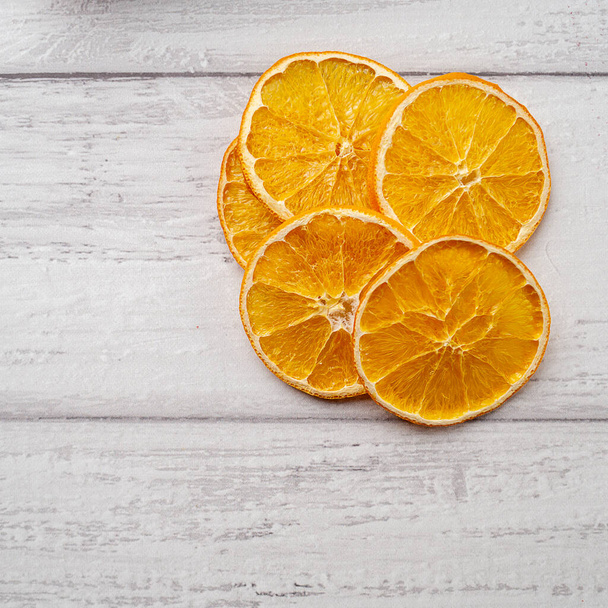 Some peaces of dried oranges on white wooden background - Foto, Bild