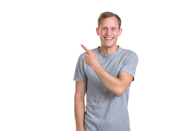 Look to the left! Young man points his finger left up, isolated on a white background. - Photo, Image