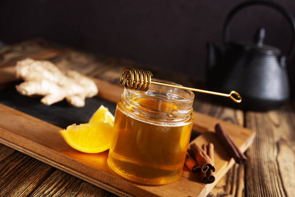 Glass bank with honey ginger lemon and cinnamon. - Fotografie, Obrázek