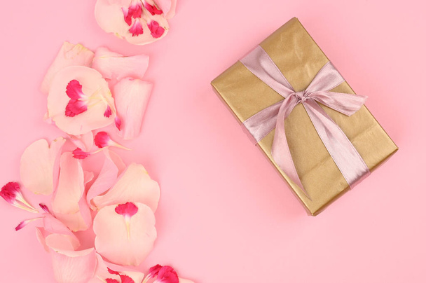 Flat lay composition with beautiful flowers and a gift box on a pink background. Space for text. - Photo, Image