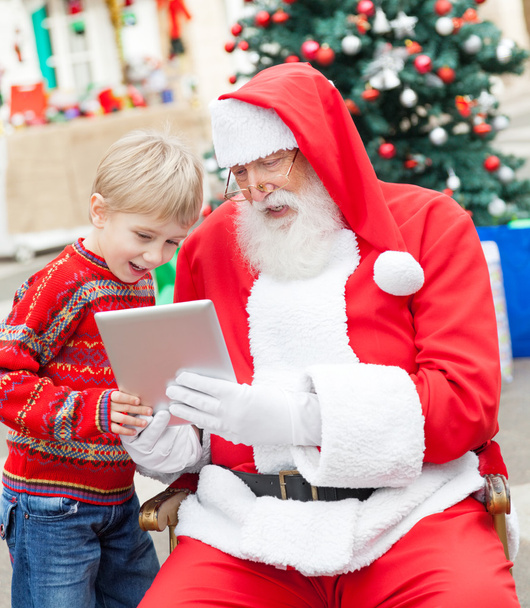 Garçon et Père Noël en utilisant la tablette numérique
 - Photo, image
