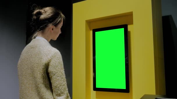 展示会で空白の緑のディスプレイウォールを見る女性 – 緑のスクリーンコンセプト - 映像、動画