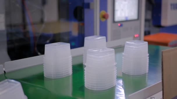 Automatikus robotgyártósor műanyag élelmiszer-tartállyal a szállítószalagon - Felvétel, videó