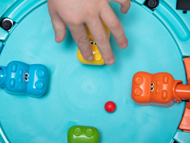 Children play a fun Board game where hippos eat balls. reaction games. educational games for children. children's hands close up - Фото, изображение