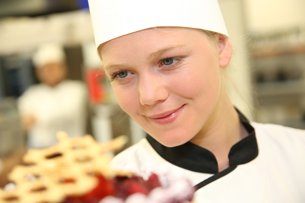 Young confectioner holding cake - Foto, Imagen