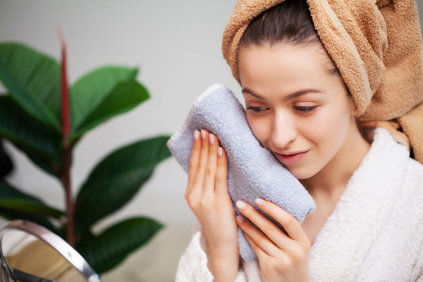Mulher limpa a toalha de rosto depois de tomar um banho
 - Foto, Imagem