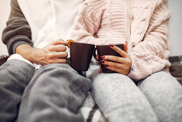 Couple sitting on a bed in a room drinking a coffee - Foto, Imagem