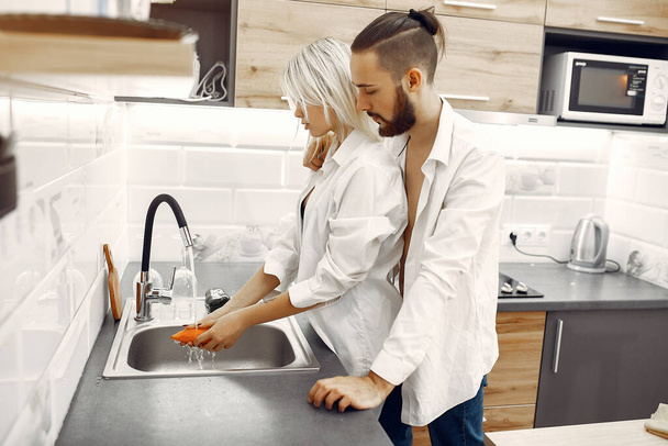 COUPLE COOKING DINNER IN THE KITCHEN - Фото, изображение
