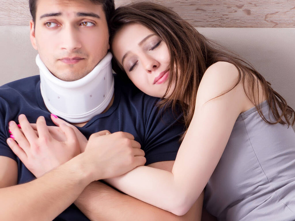 Liebevolle Ehefrau kümmert sich um verletzten Ehemann im Bett - Foto, Bild