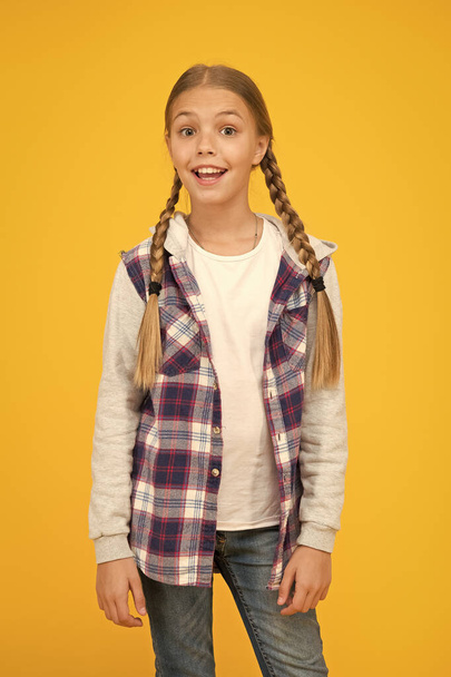 hipster girl yellow wall. school girl casual style. autumn kid fashion. child cute blond hair. childhood happiness. happy childrens day. small girl checkered jacket. Born To Be The Best - Foto, Imagen
