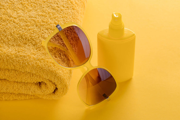 Sunglasses, towel and sunscreen spray - Valokuva, kuva
