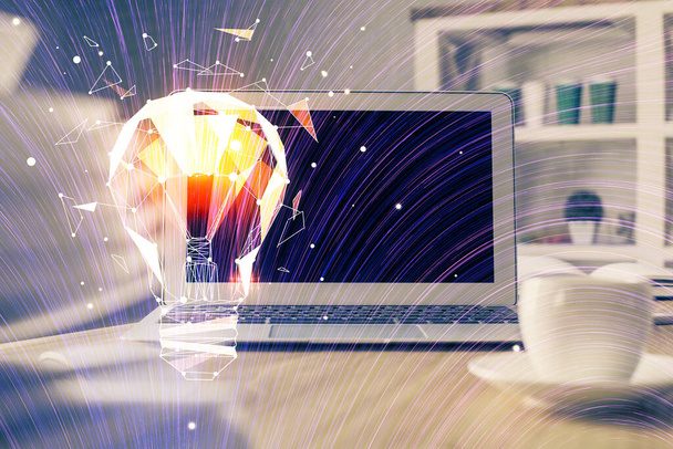 Computer on desktop in office with bulb icon hologram. Multi exposure. Concept of idea. - Foto, Bild