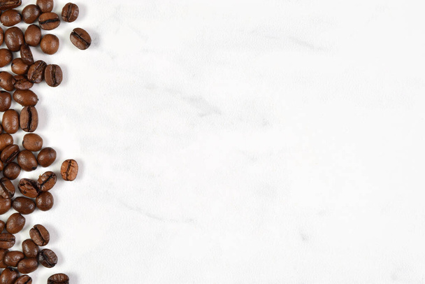 Fresh french vanilla coffee beans scattered on a white marble background with plenty of room for copy. - Foto, Bild
