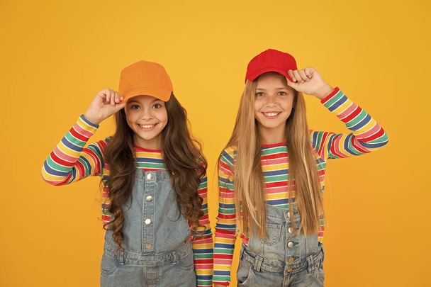 The hipster subculture. Happy little hipsters wearing baseball caps on yellow background. Cute small hipsters smiling with fashionable look. Adorable children in hipster style - Photo, Image