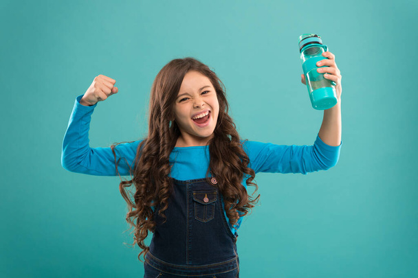 Power and activity. Drinking water for health care and body balance. thirsty kid has power. drink water preventing dehydration. small girl hold bottle. detox and people. healthy drink for teen child - Photo, Image