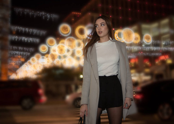 Sexy gorgeous brunette girl portrait in night city lights. Vogue fashion style portrait of young pretty beautiful woman with long dark hair. Shallow DOF. Girl and the night city. Night city. Portrait - Photo, Image