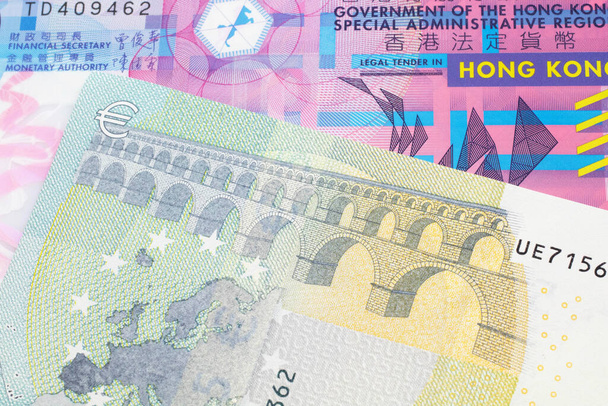 Un colorido billete de diez dólares de Hong Kong disparado en macro con un billete azul y verde, de la Unión Europea, cinco euros
 - Foto, imagen