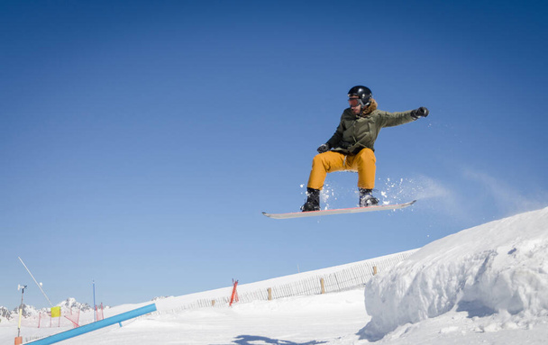 Saltando snowboarder com um céu azul e ensolarado em Zermatt, os Alpes Suíços
 - Foto, Imagem