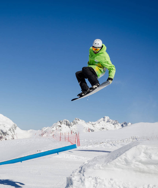 Πηδώντας snowboarder με ένα μπλε και ηλιόλουστο ουρανό στο Zermatt, οι ελβετικές Άλπεις - Φωτογραφία, εικόνα