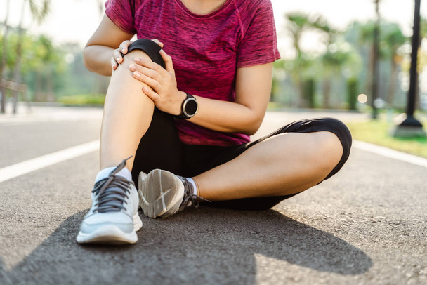 knee Injuries. sport woman with strong athletic legs holding knee with her hands in pain after suffering muscle injury during a running workout training on Running Track. Healthcare and sport concept. - Fotoğraf, Görsel