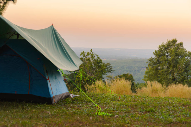 日没の山々を見下ろす牧草地の間で観光テント。屋外キャンプ - 写真・画像